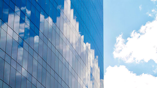 Reflets de nuages sur une façade vitrée d'un immeuble moderne